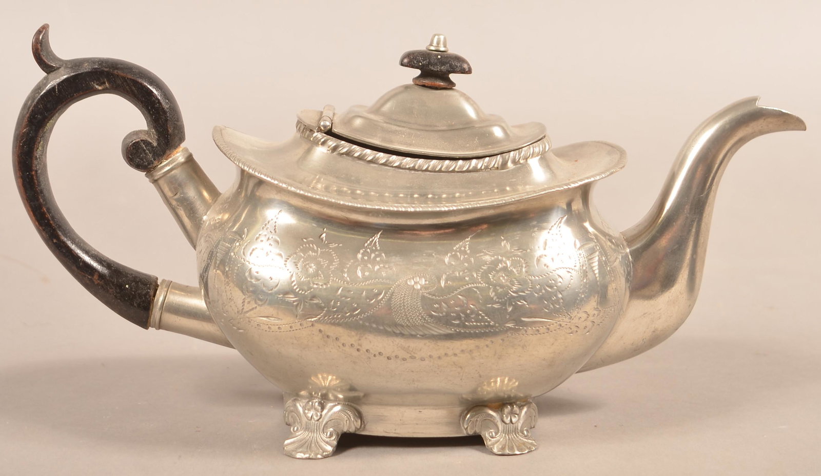Unsigned Pewter Boat Form Shell Foot Teapot.: Unsigned Pewter Boat Form Shell Foot Teapot. Attributed to Israel Trask Beverly, Mass., 1807–1856. Floral and foliate bright-cut decoration. 6-1/2"h. Condition: Good with wear.
