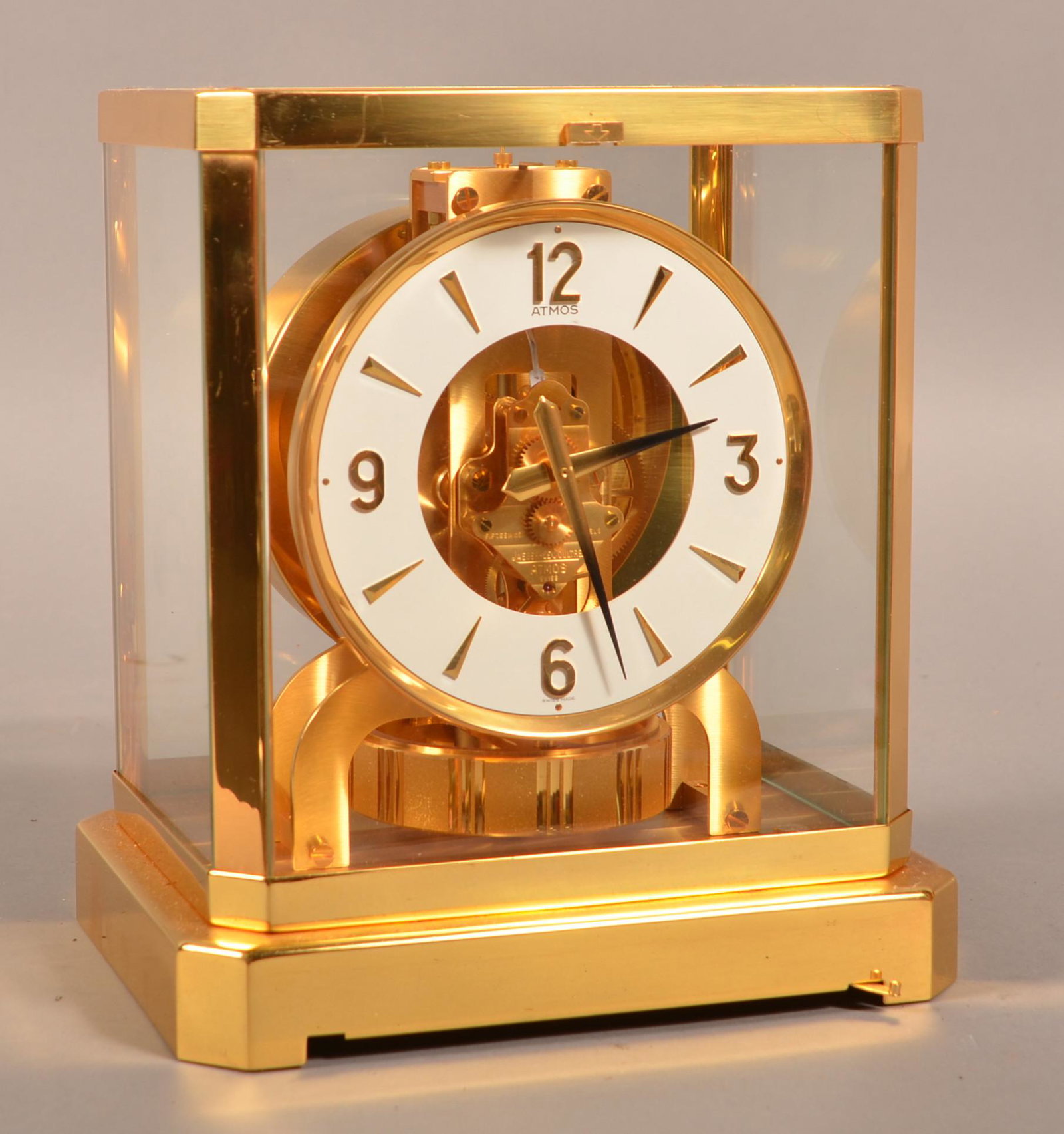 Jaeger LeCoultre "Atmos" Brass Shelf Clock.: Jaeger LeCoultre "Atmos" Brass Shelf Clock. Glazed brass rectangular case housing the torsion pendulum movement attached to a circular white enameled dial with Arabic hour markers and brass hands. SN-
