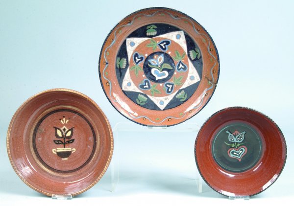Three Left Handed Russell Henry Pottery Bowls, brow: Three Left Handed Russell Henry Pottery Bowls, brown ground with polychrome tulip, heart and geometric decoration, inscribed on bottom Henry's name and 72- 74 dates, etc. on all, 9-1/2"dia., 8-1/2"dia