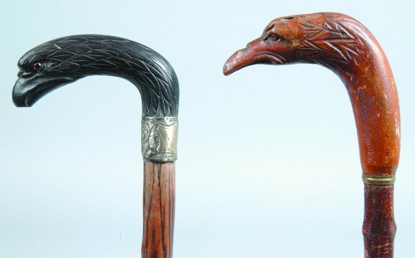 Two Caved Wood Eagle Head Handled Canes, one paint: Two Caved Wood Eagle Head Handled Canes, one painted black with applied glass eyes and metal collar with empty cartouche and floral decorations, metal ferrule, other natural finish, both with wood sha