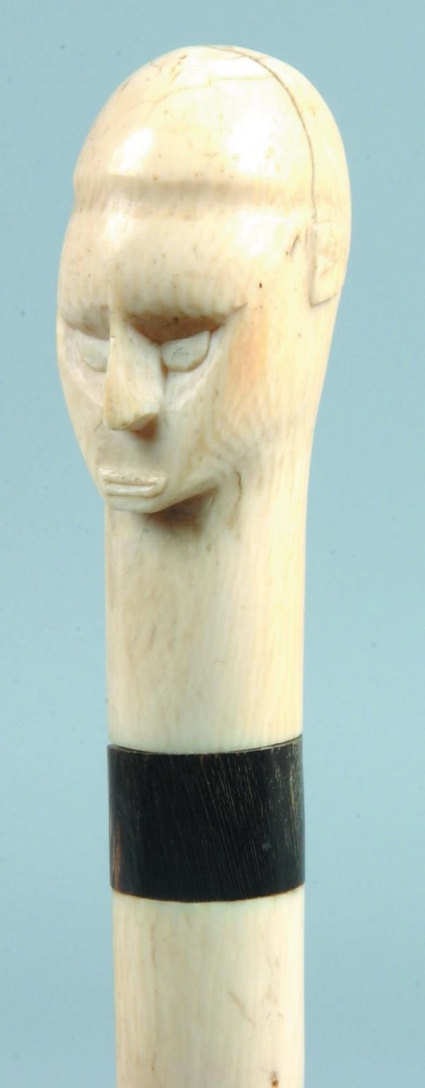 Carved Ivory Human Head Form Handled Cane, stylize: Carved Ivory Human Head Form Handled Cane, stylized head with horn and ivory collar, wood shaft, 34-¼"l., (split to head).