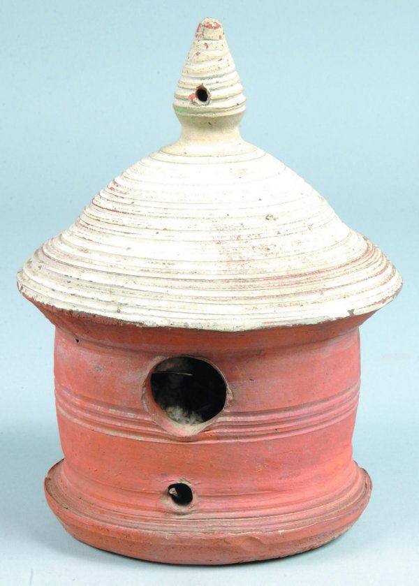 Redware Bird House, cylindrical form, conical roof: Redware Bird House, cylindrical form, conical roof and finial, round entrance and perch holder, incised banding decoration, unglazed with white painted roof, 10-½"h. x 8"dia., (minor chips).