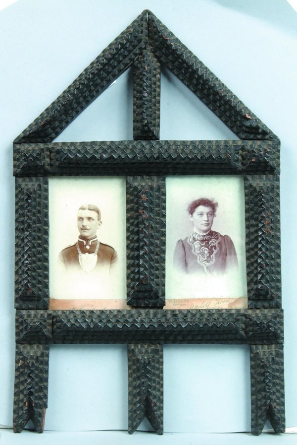 Tramp Art Picture Frame with Photo of German Coup: Tramp Art Picture Frame with Photo of German Couple, wood frame with geometric patterns and applied serrated edged tiers, painted black , 12"h. x 7-1/2"w., (minor losses).
