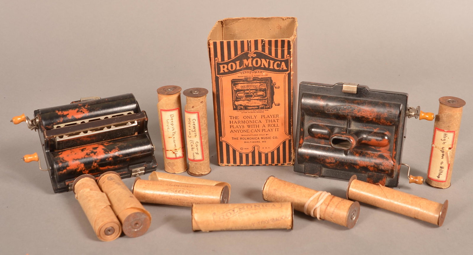 Bakelite Chromatic Rolmonica Player Harmonica.: Two Bakelite Chromatic Rolmonica Player Harmonica, Circa 1928. One with box, Includes 11 rolls. Marked, "Made by the Rolmonica Music Co., Baltimore, MD. 5" x 4-1/2" x 3". Condition: Very good with use