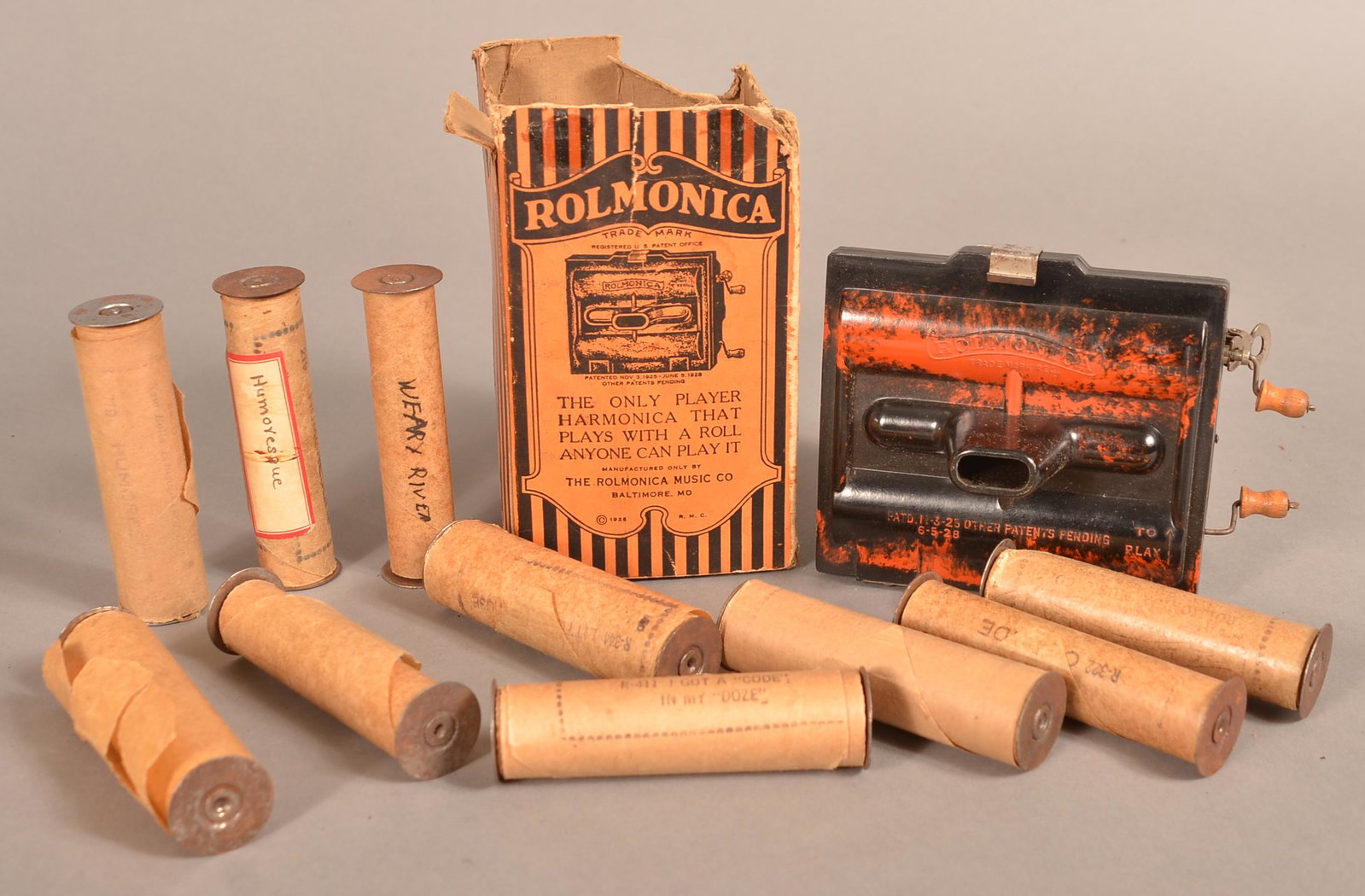 Bakelite Chromatic Rolmonica Player Harmonica.: Two Bakelite Chromatic Rolmonica Player Harmonica, Circa 1928. Includes 11 rolls. Marked, "Made by the Rolmonica Music Co., Baltimore, MD. 5" x 4-1/2" x 3". Condition: Very good with use wear. Box is 