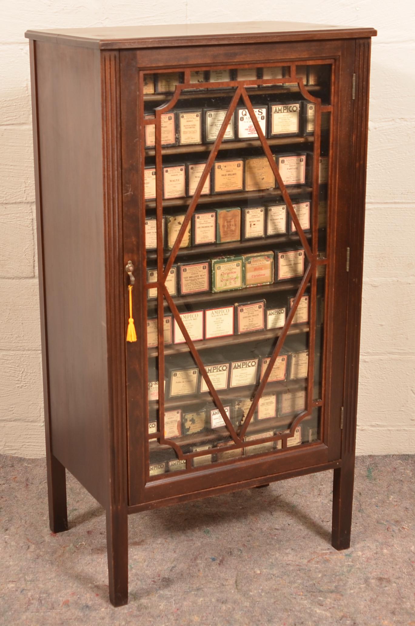 Antique Mahogany Music Cabinet w/73 Ampico Rolls.: Antique Mahogany Music Cabinet with 73 Ampico Rolls. Fretwork colorless glass door with fluted stiles. 46"h. x 24-1/4"w. x 16-1/2"d. Condition: Very good with minor wear.