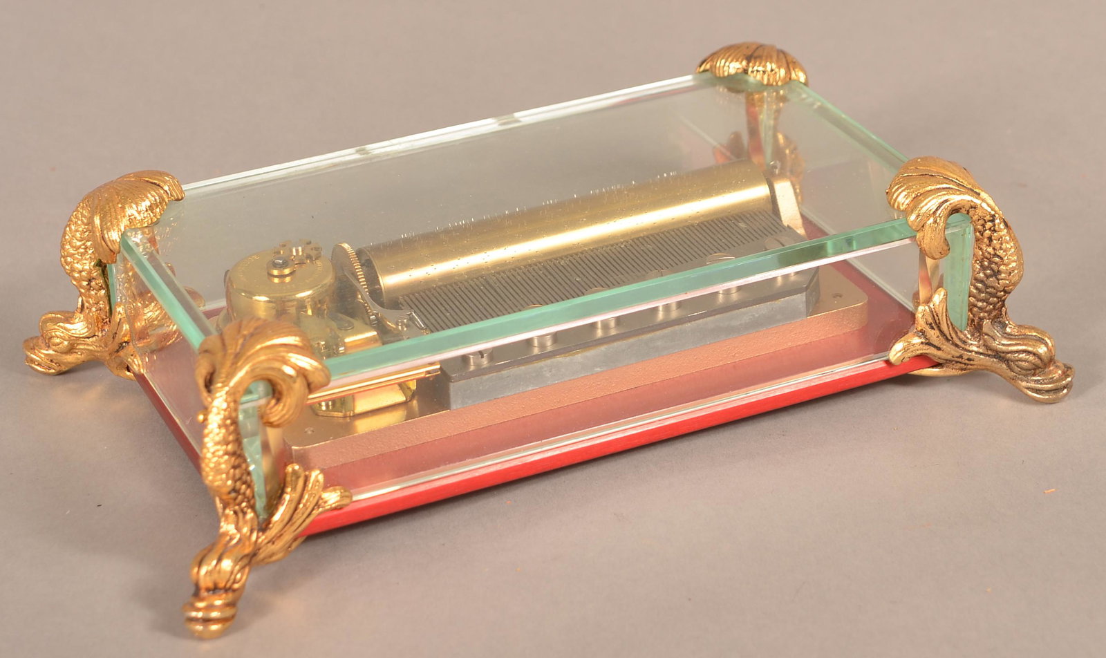 Vintage Reuge Swiss Cylinder Music Box.: Vintage Reuge Swiss Cylinder Music Box. Gilt Brass and Glass Music Box, gilt dolphin feet. Sainte-Croix, Switzerland, playing Hungarian Rhapsody (3 parts). 2-1/2"h. x 9-1/2"w. x 6"d. Condition: Very g