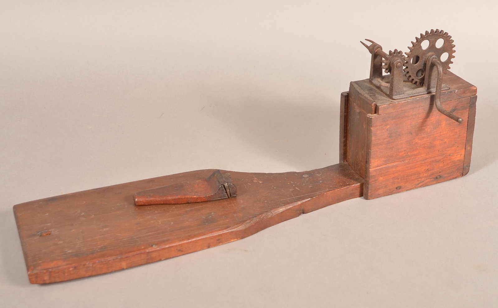 19th Century Wood and Metal Apple Peeler.: 19th Century Wood and Metal Apple Peeler. Unusual form with slide-lid storage, crank action with plank base. 24"l. overall. Condition: Good with use wear.
