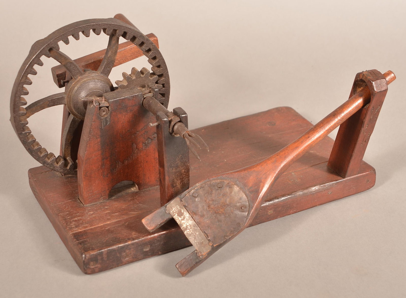 19th Century Wooden Apple Peeler.: 19th Century Wooden Apple Peeler. Crank action with cast metal gears and wood plank base. 15"l. overall. Condition: Good with use wear.