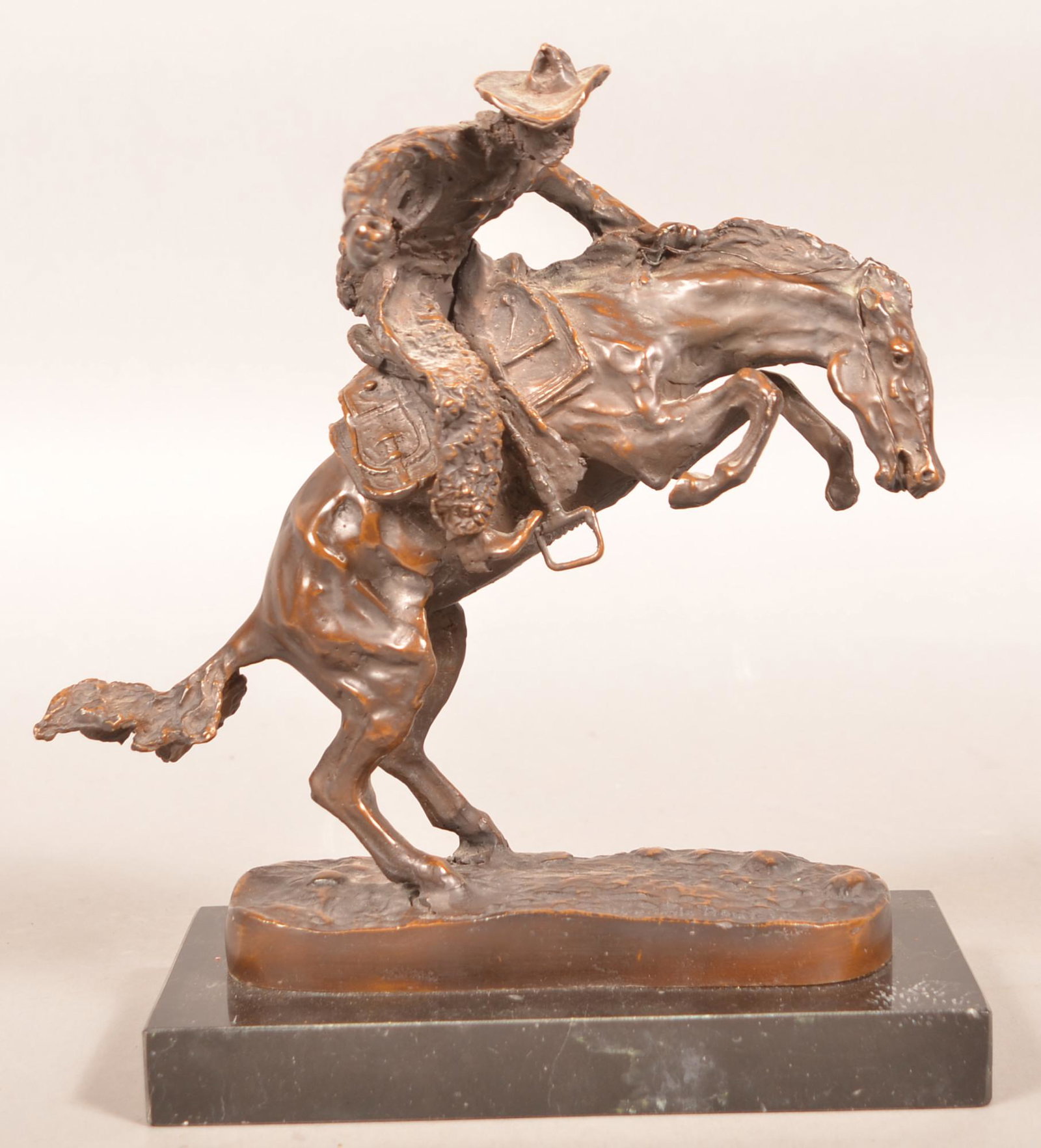 After Frederic Remington Bronze Bronco Buster.: After Frederic Remington Bronze Bronco Buster. Mounted on a marble base. 11-1/2"h. Condition: Good, missing whip.