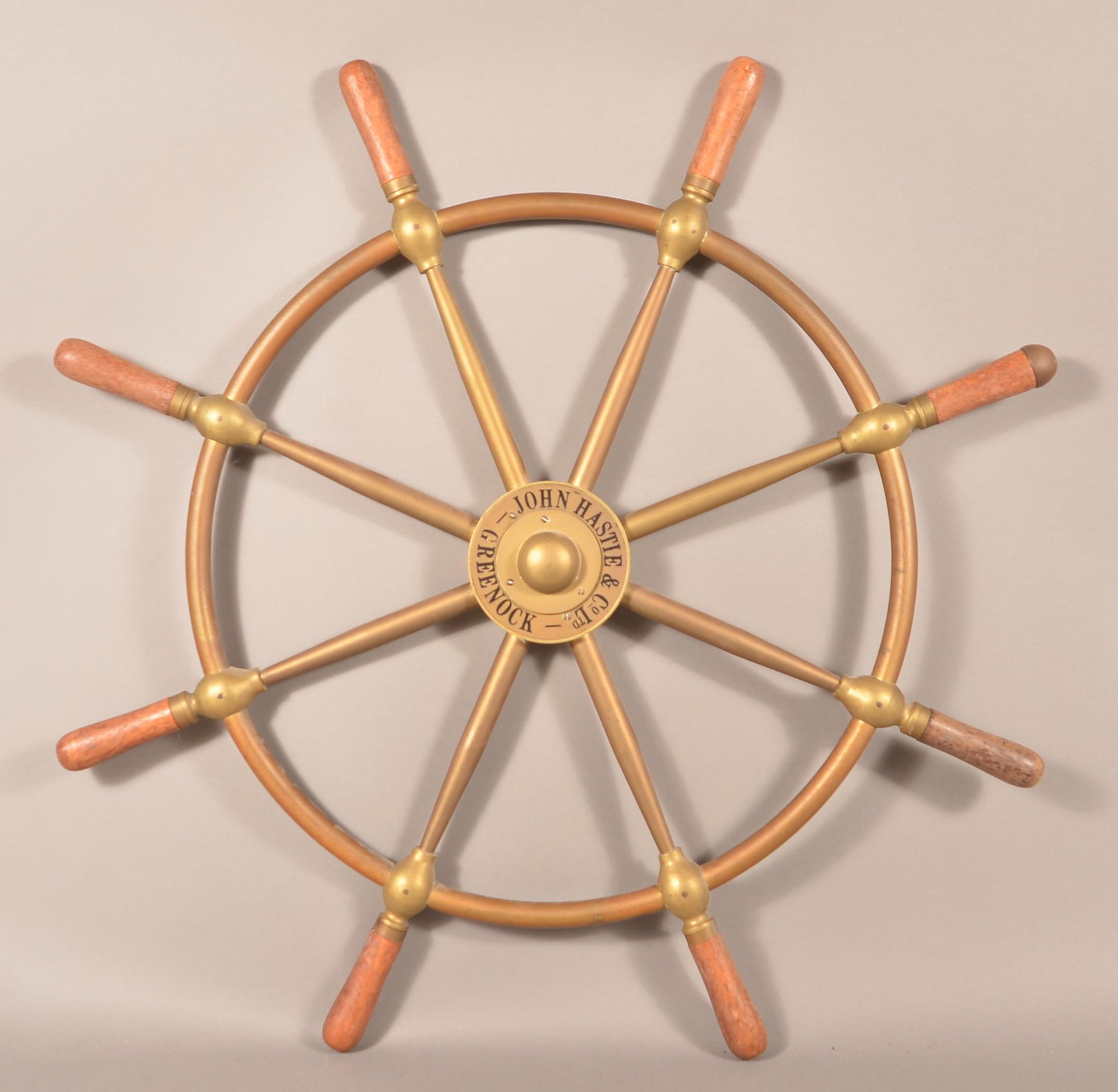 Antique Scottish Brass Ships Wheel.: Antique Scottish Brass Ships Wheel. Signed "John Hastie & Co. Ltd., Greenock". Turned wood handles with eight spokes. 29-1/2" diam. Condition: Very good.