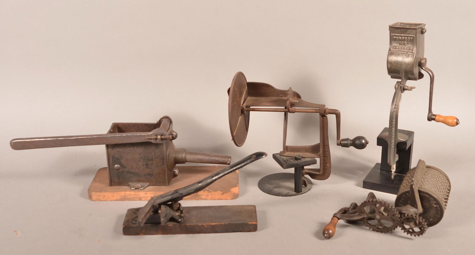 Five Various Antique Metal Kitchen Gadgets.: Five Various Antique Metal Kitchen Gadgets. Sausage stuffer, slicer, nut cracker, grater and ice crusher. Tallest 13"h. Condition: Good with scattered rust and use wear.