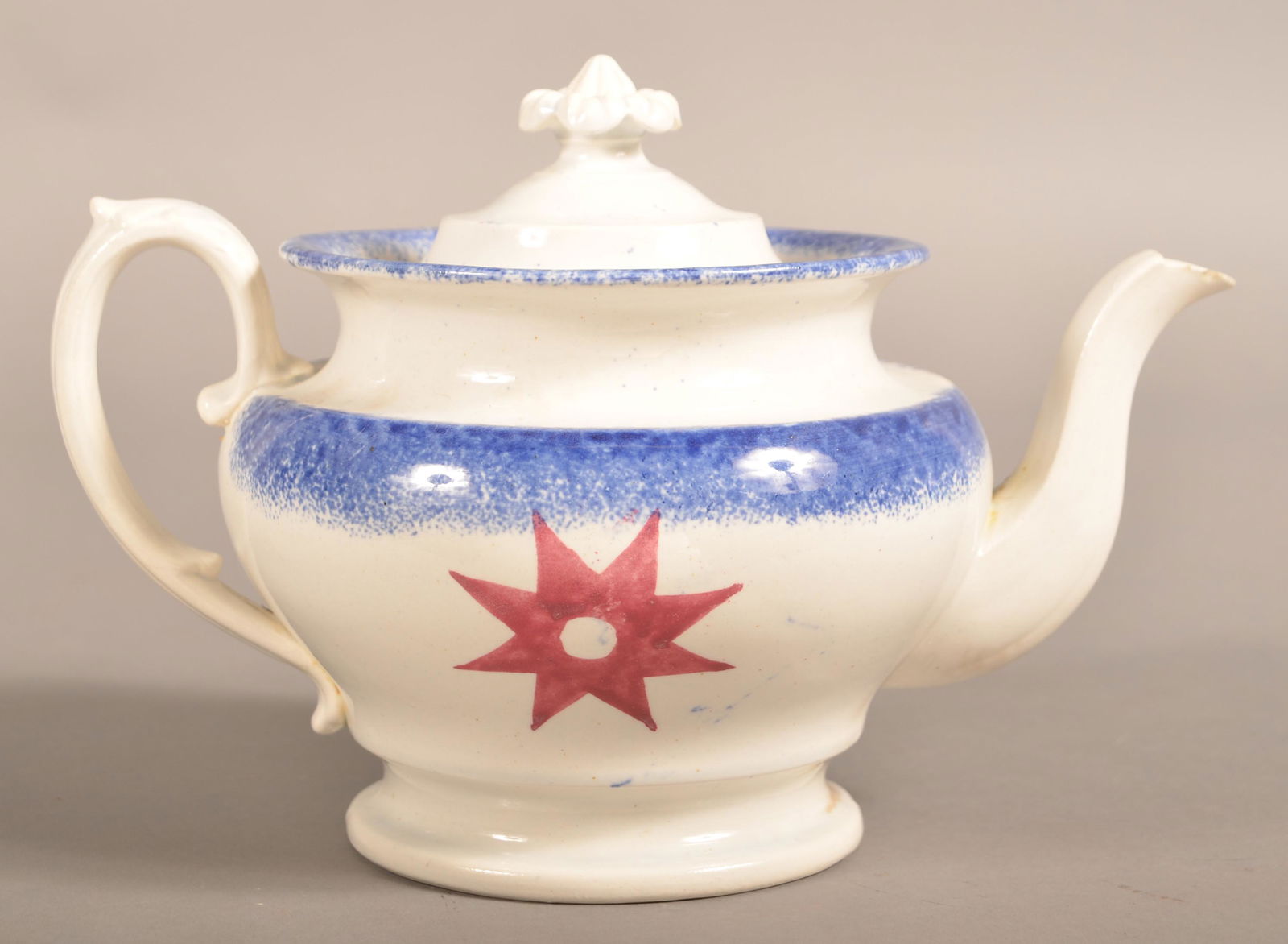 Blue Spatter China 8-Pointed Compass Star Teapot.: Blue Spatter China 8-Pointed Compass Star Pattern Teapot. Double-sided decoration with red compass star design. 7"h. Condition: Hairline on base and small chips on spout.