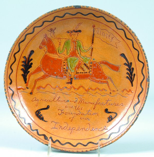 Greg Shooner 2002 Redware Plate, Sgraffito and slip: Greg Shooner 2002 Redware Plate, Sgraffito and slip decorated of gentleman riding horse back and holding flag marked Unity, also lower bottom inscribed Agriculture and Manufactures are the Foundation