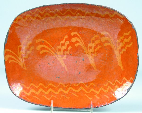 Greg Shooner 2004 Redware Slip Decorated Platter ha: Greg Shooner 2004 Redware Slip Decorated Platter having central sprig and wavy line border decorations, 10" x 12-3/8"dia., (good condition with intentional wear chips).