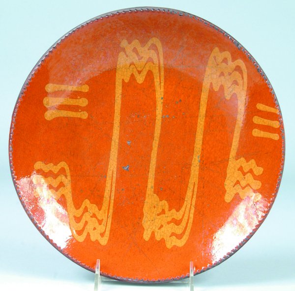 Greg Shooner 2004 Redware Slip Decorated Plate havi: Greg Shooner 2004 Redware Slip Decorated Plate having wavy and line decorations, also inscribed on back Warren County Ohio, 11"dia., (good condition with hit mark).
