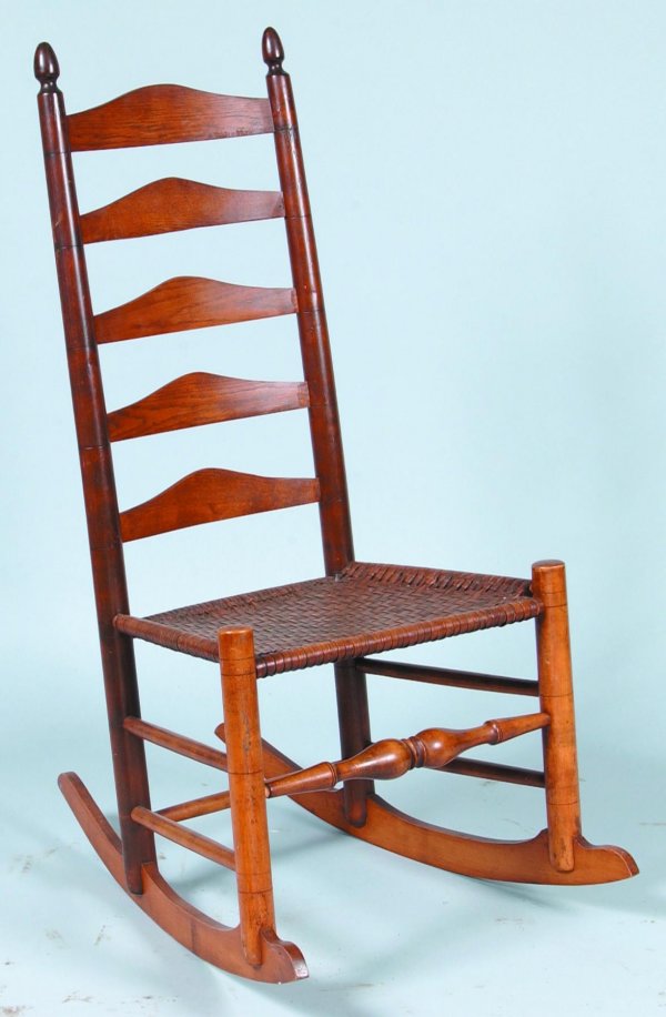 Mixed wood Ladder-back Rocking Chair with woven sp: Mixed wood Ladder-back Rocking Chair with woven splint seat. Conical finials, arched ladder-back, boldly turned front stretcher and cheese cutter rockers. Condition: Refinished. 42 ½"h overall, seat 