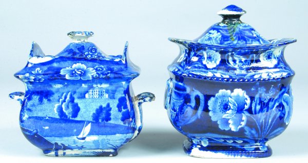 Two various Staffordshire Blue Transfer China cove: Two various Staffordshire Blue Transfer China covered sugar bowls; scenic view with sail boat, 5" h, and floral and foliate design, 6 ½" h. Condition: Both having chips and repairs.