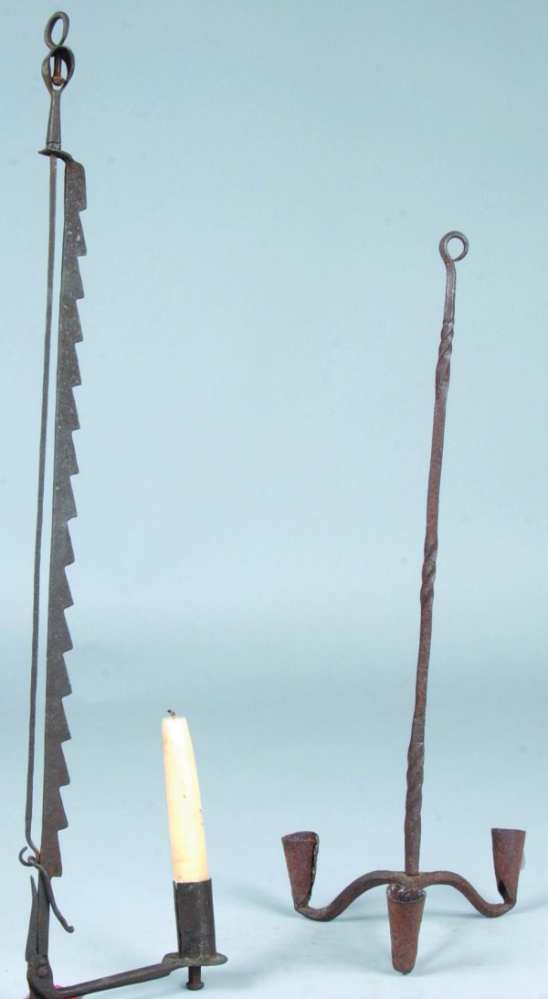 Two Wrought Iron Lighting Devices, first is an Adj: Two Wrought Iron Lighting Devices, first is an Adjustable Sawtooth trammel form Candle and Rush Holder, second is a Three Socket Hanging chandelier,27"h.-20"h. Good.