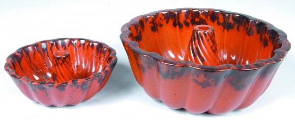 Two Redware Turk's Head Molds, scalloped edge with: Two Redware Turk's Head Molds, scalloped edge with spiral form post, orange and manganese glazed, 3"h. x 7-1/4"dia., 4-1/4"h. x 10-5/8"dia., (smaller with normal edge chips, larger with restoration on