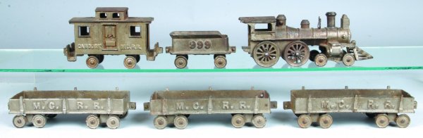 Six Piece Cast Iron Floor Train Set marked M.C. R.: Six Piece Cast Iron Floor Train Set marked M.C. R. R. and 999 on tender, steam engine, tender, 3 gondolas and caboose, nickel finish, 2-1/4"h.-4-1/4"h., (worn and engine missing parts).
