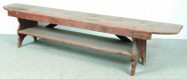 Pennsylvania Softwood Mortised-leg Bench with Lowe: Pennsylvania Softwood Mortised-leg Bench with Lower Shelf. Shaped cut-out legs, front with skirt and back with reinforcing battens. 18 ½"h x 84"l x 14"d. Condition: Worn with added nails and wood res