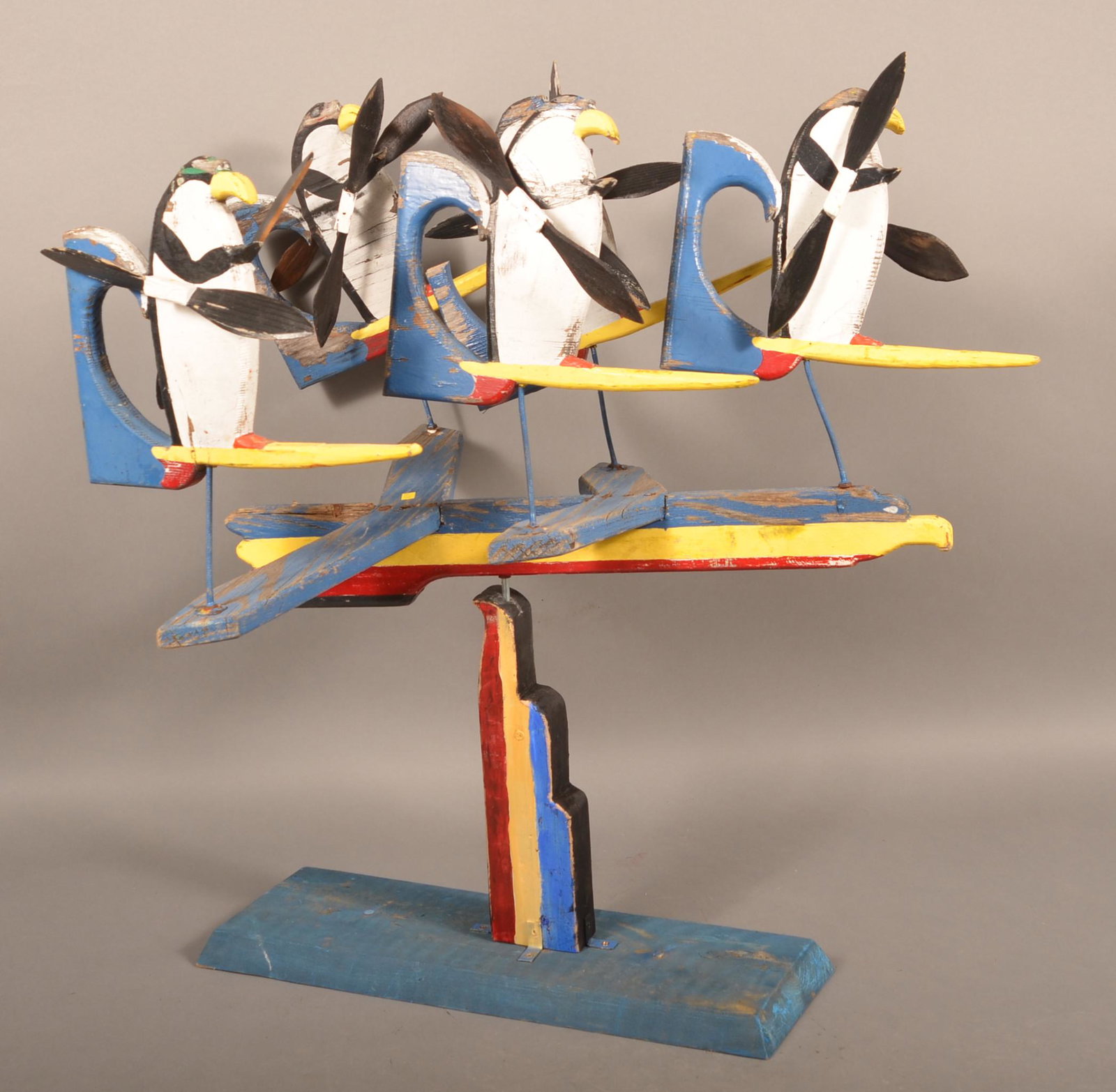 Vintage Folk Art Painted Wood Whirligig.: Vintage Folk Art Painted Wood Whirligig. Penguins on thunderbird. 34"h. x 32"l. x 22"w. Condition: Good with wear and losses.
