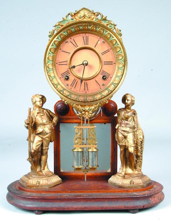 Unmarked Ansonia "Crystal Palace Extra" Clock with: Unmarked Ansonia "Crystal Palace Extra" Clock with glass dome top, brass works, Roman numeral paper dial with brass floral and scroll frame, small mirrored back, two cast metal statuettes on oak woode
