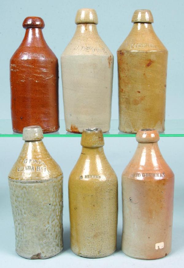 Six Stoneware Pottery Salt Glazed Beer Bottles wit: Six Stoneware Pottery Salt Glazed Beer Bottles with impressed names; A.W. ABAHR, F. GOSSMAN, G. JONES, G. GRUMAN, J. DEVINE, D. BENDER. 9-1/2" to 10" high. Condition: Some chips