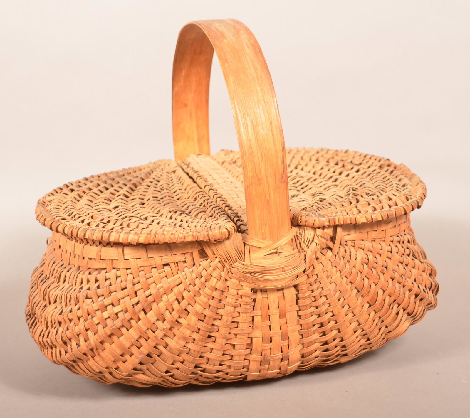 Antique Woven Oak Splint Picnic Basket.: Antique Woven Oak Splint Picnic Basket. Oblong form with bulbous sides, bentwood handle and double-hinged lid. 14-1/2"h. x 17"w. x 12"d. Condition: Good with minor breaks and losses.