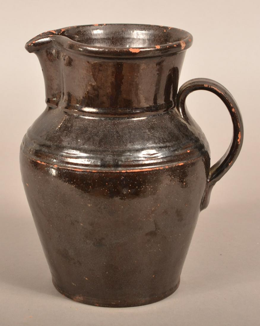 D. Cope, Chester County, PA Glazed Redware Pitcher.: Chester County, PA 19th Century Manganese Glazed Redware Pitcher. Stamped on base "D. Cope". 8-3/4"h. Condition: Good with glaze pops, hairlines and tiny chips.