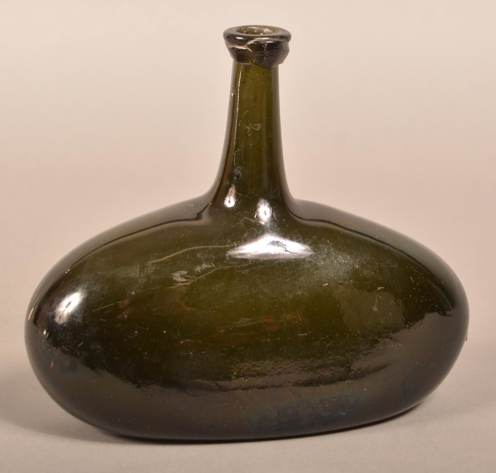 Blown Dark Olive Green Glass Chestnut Bottle.: Blown Dark Olive Green Glass Chestnut Bottle. Squat form with applied rounded mouth, tapered elongated spout concave base and broken pontil. 7-1/4"h. Condition: Good with wear.