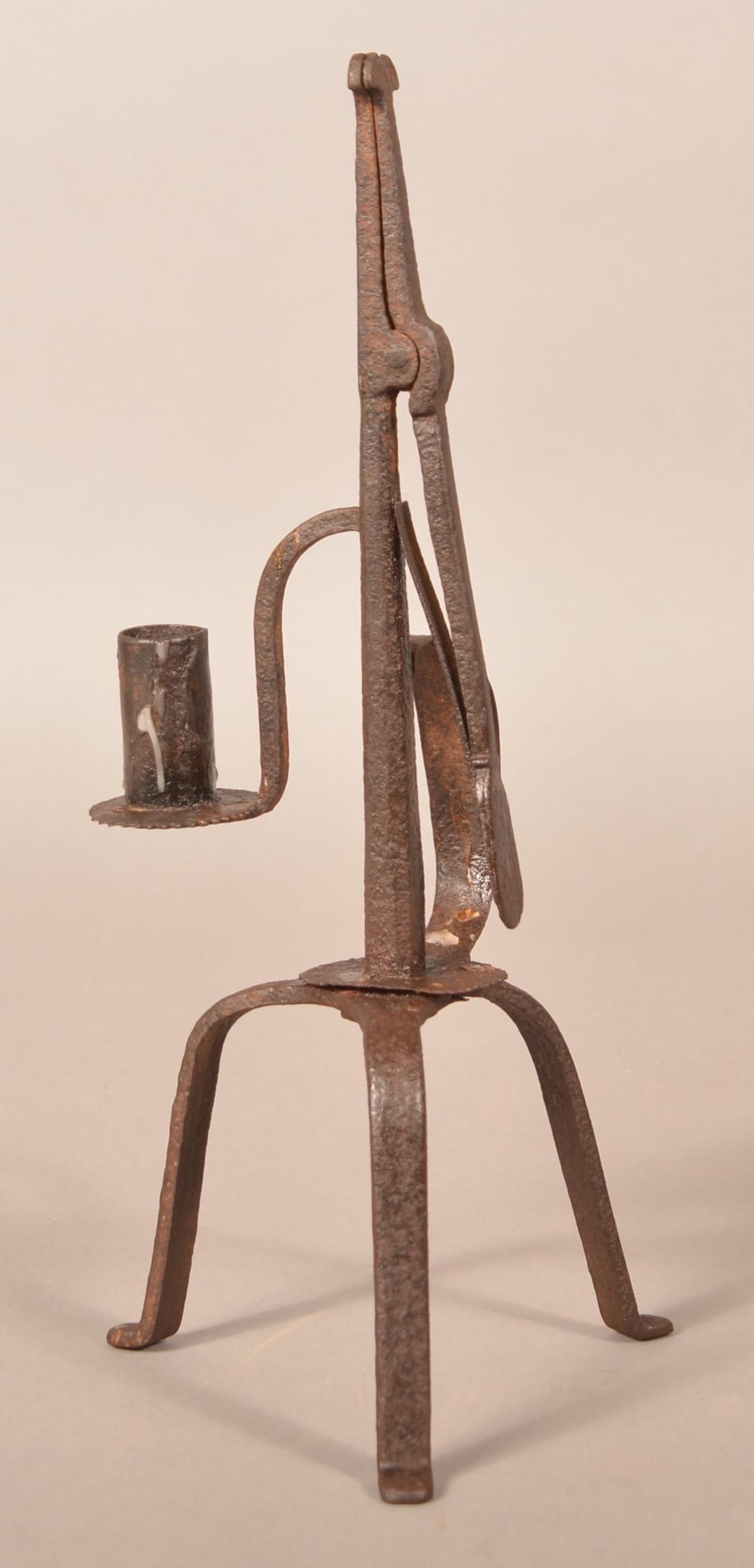 Early 19th Century Wrought Iron Combination Lamp.: Early 19th Century Wrought Iron Combination Lamp. Spring tongs type rush holder and candle socket with sawtooth tray, D-guard hand grip with sawtooth mounting and tripod base. 12-3/4"h. Condition: Goo