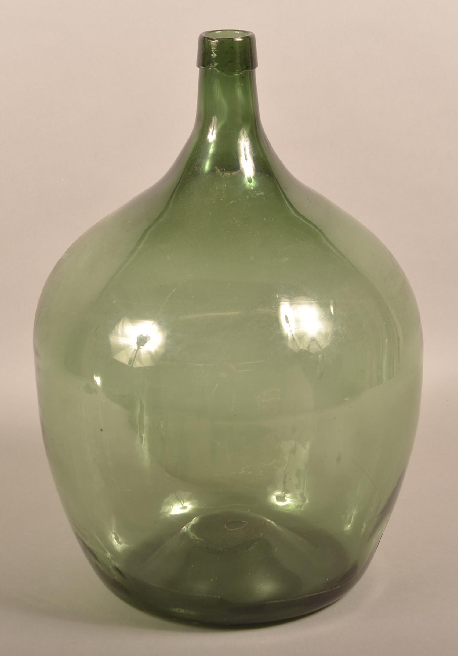 Early 19th Century Blown Olive Glass Demijohn Bottle.: Early 19th Century Blown Olive Glass Demijohn Bottle. Tapered elongated spout, ovoid body and concave base with pontil. 21"h. Condition: Good with wear.