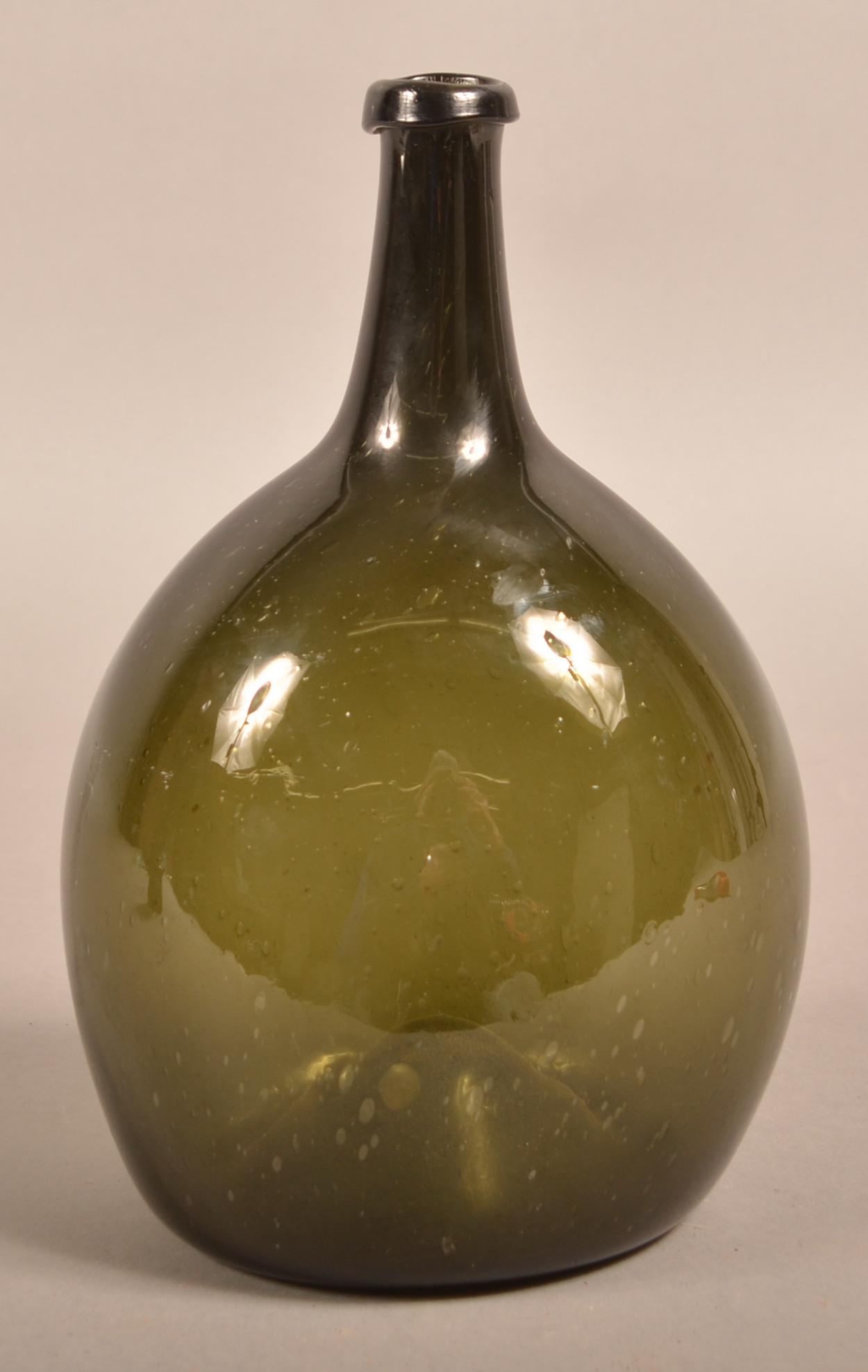 Early 19th Century Free-Blown Olive Green Glass Bottle.: Early 19th Century Free-Blown Olive Green Glass Bottle. Ovoid body, tapered neck with applied mouth and concave base with pontil. 10"h. Condition: Very good.
