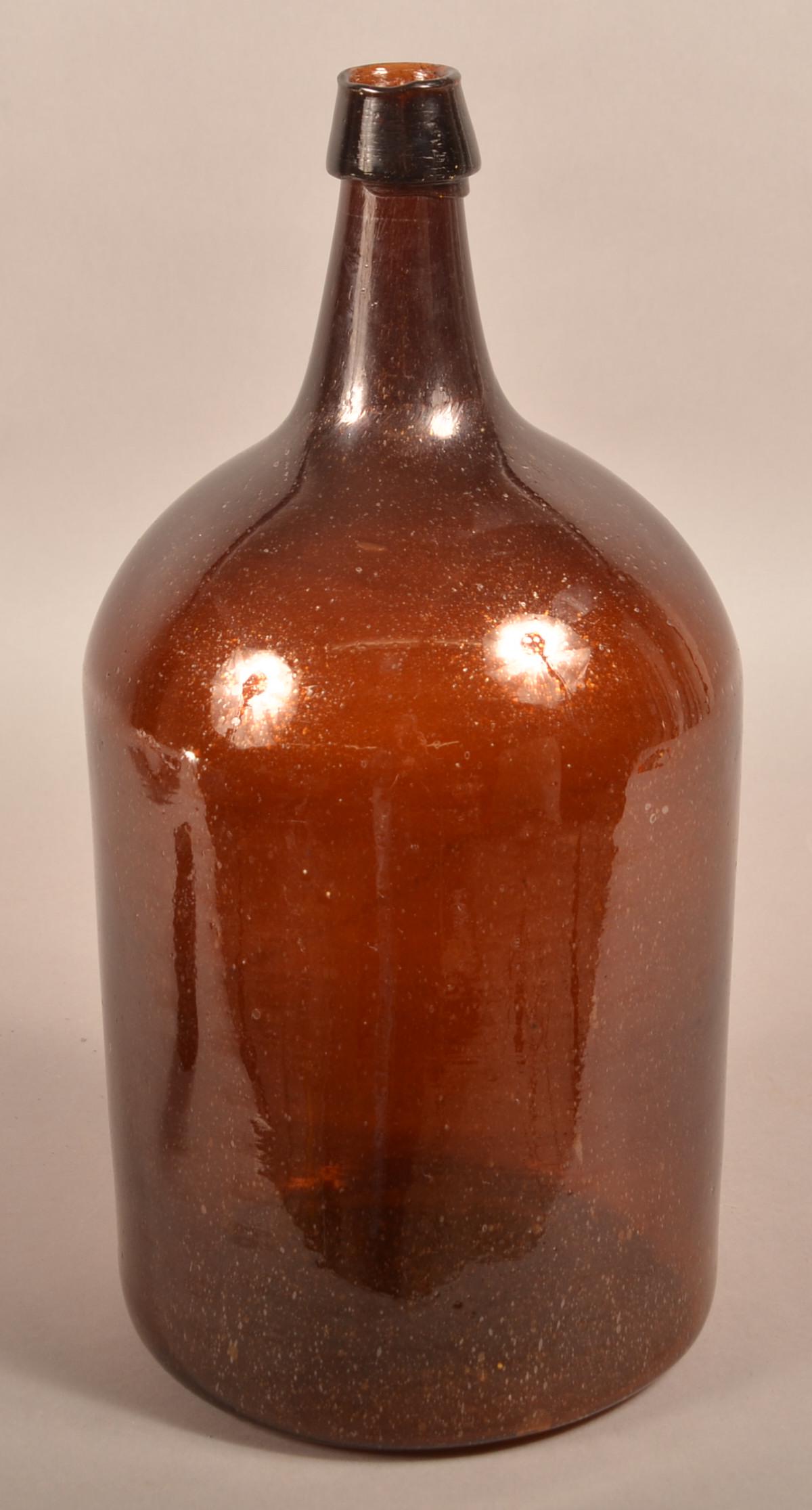 Large 19th Century Deep Amber Glass Bottle.: Large 19th Century Deep Amber Glass Bottle. Applied tapered mouth, tapered elongated neck, rounded shoulder and straight sides. Possibly Stoddard Glass Works, NH. 18"h. Condition: Very good.
