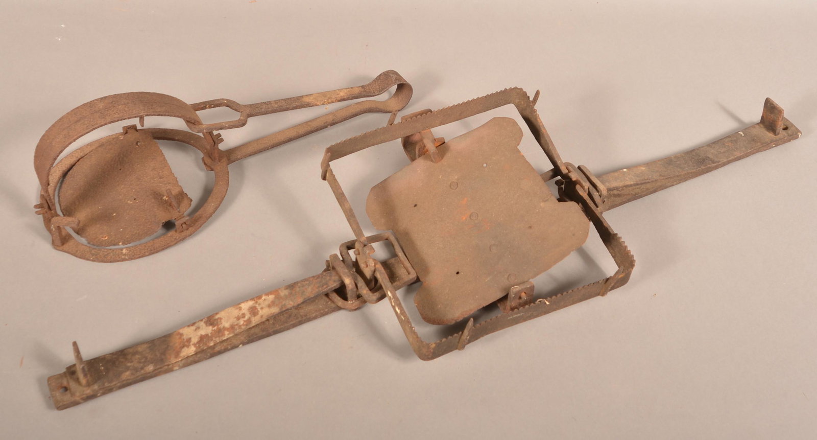 Two Antique Wrought Iron Wolf or Bear Traps.: Two Antique Wrought Iron Wolf or Bear Traps. Single spring 20"l. and double spring 41"l. Condition: Fair to good with minor loss, rust and pitting.