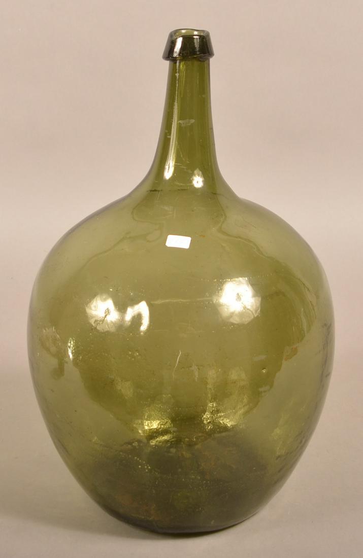 Large Olive Green Blown-Mold Glass Demijohn Bottle.: Large Olive Green Blown-Mold Glass Demijohn Bottle. Applied collar lip, conical neck, bulbous body and concave base with pontil. 17"h. Condition: Good with wear.
