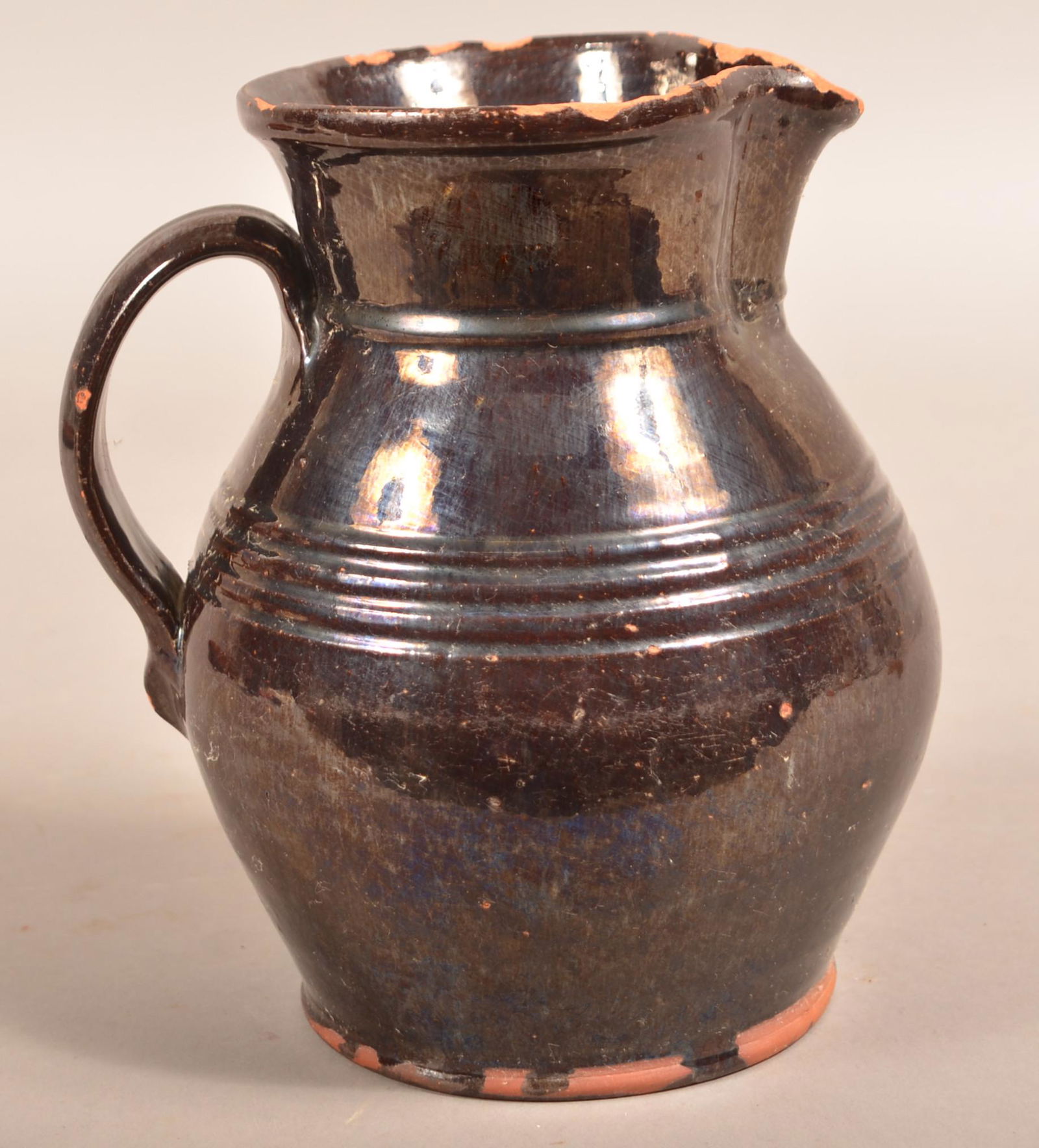 D. Cope, Chester County, PA Glazed Redware Pitcher.: Chester County, PA 19th Century Manganese Glazed Redware Pitcher. Stamped on base "D. Cope". Bulbous form with embossed shoulder rings, pinched spout and applied loop handle. 8-1/2"h. Condition: Good