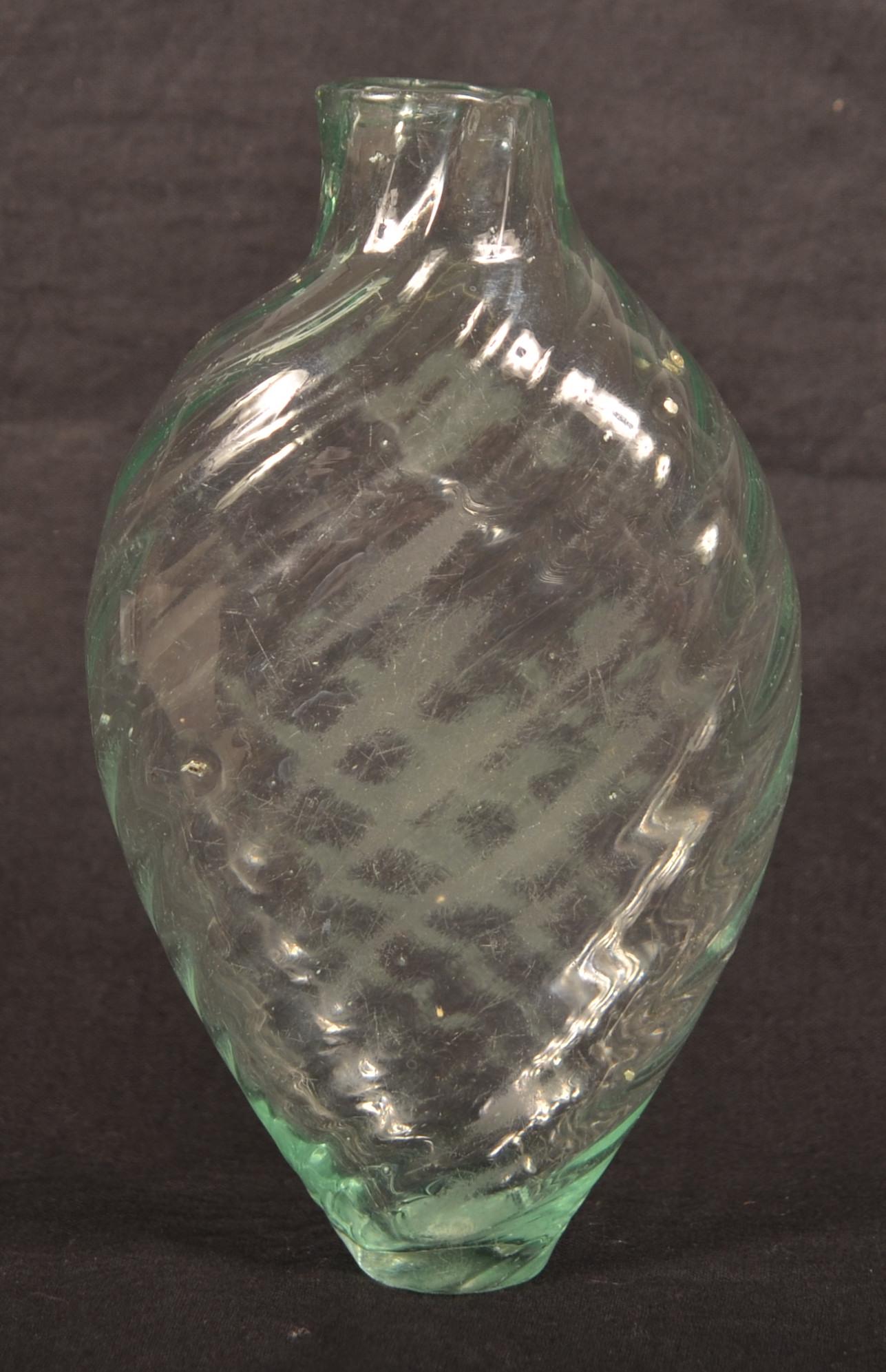 American Blown Aqua/Green Glass Pattern-Molded Flask.: American Blown Aqua/Green Glass Pattern-Molded Flask. Circa 1800-1835. Ovoid body, swirl pattern with pontil. 5-1/2"h. Condition: Good with wear.