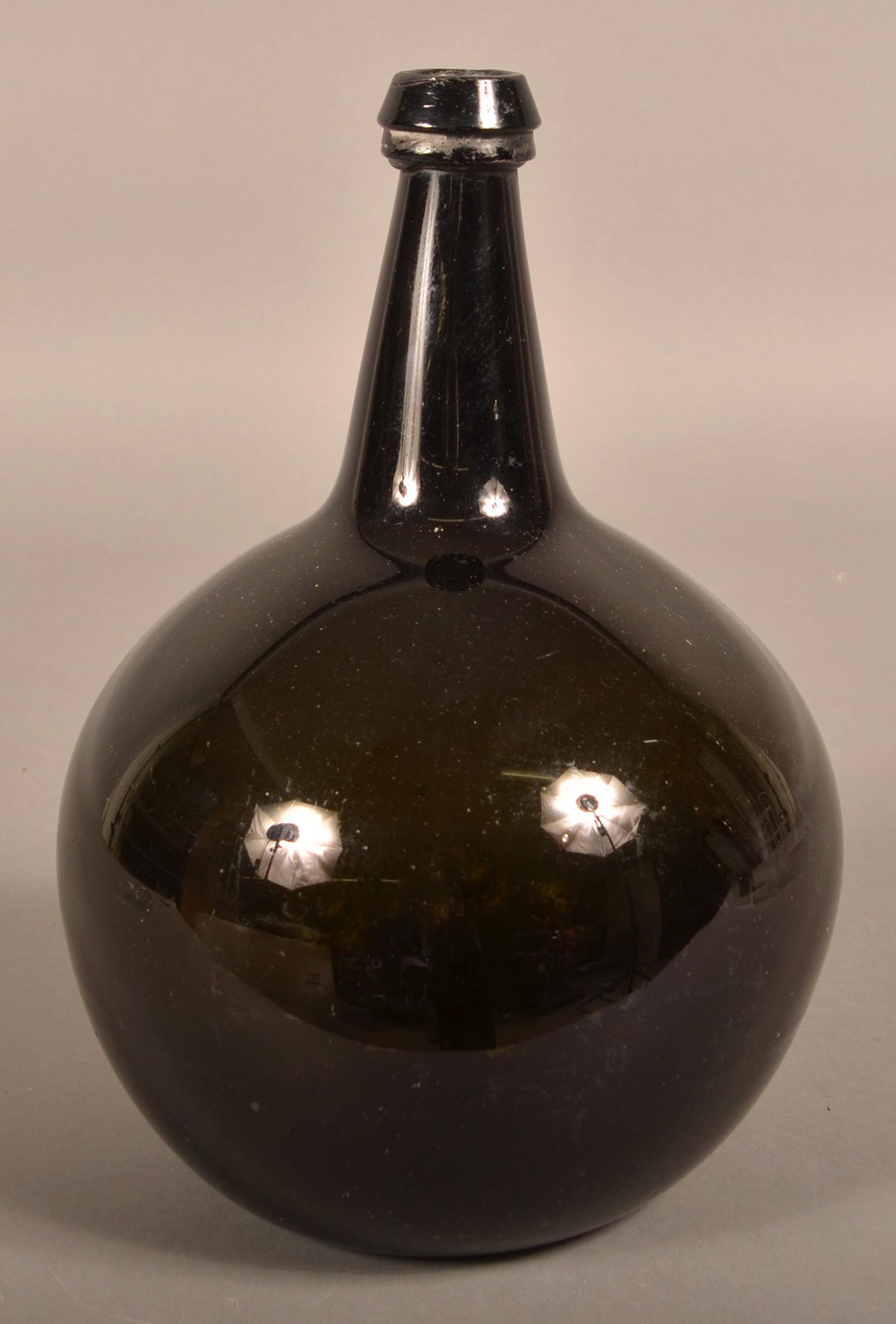 18th/19th Century Free-Blown Glass Utility Bottle.: 18th/19th Century Free-Blown Glass Utility Bottle. Dark olive green globular body with elongated neck, applied tapered mouth and concave base with pontil. 12"h. Condition: Very good.