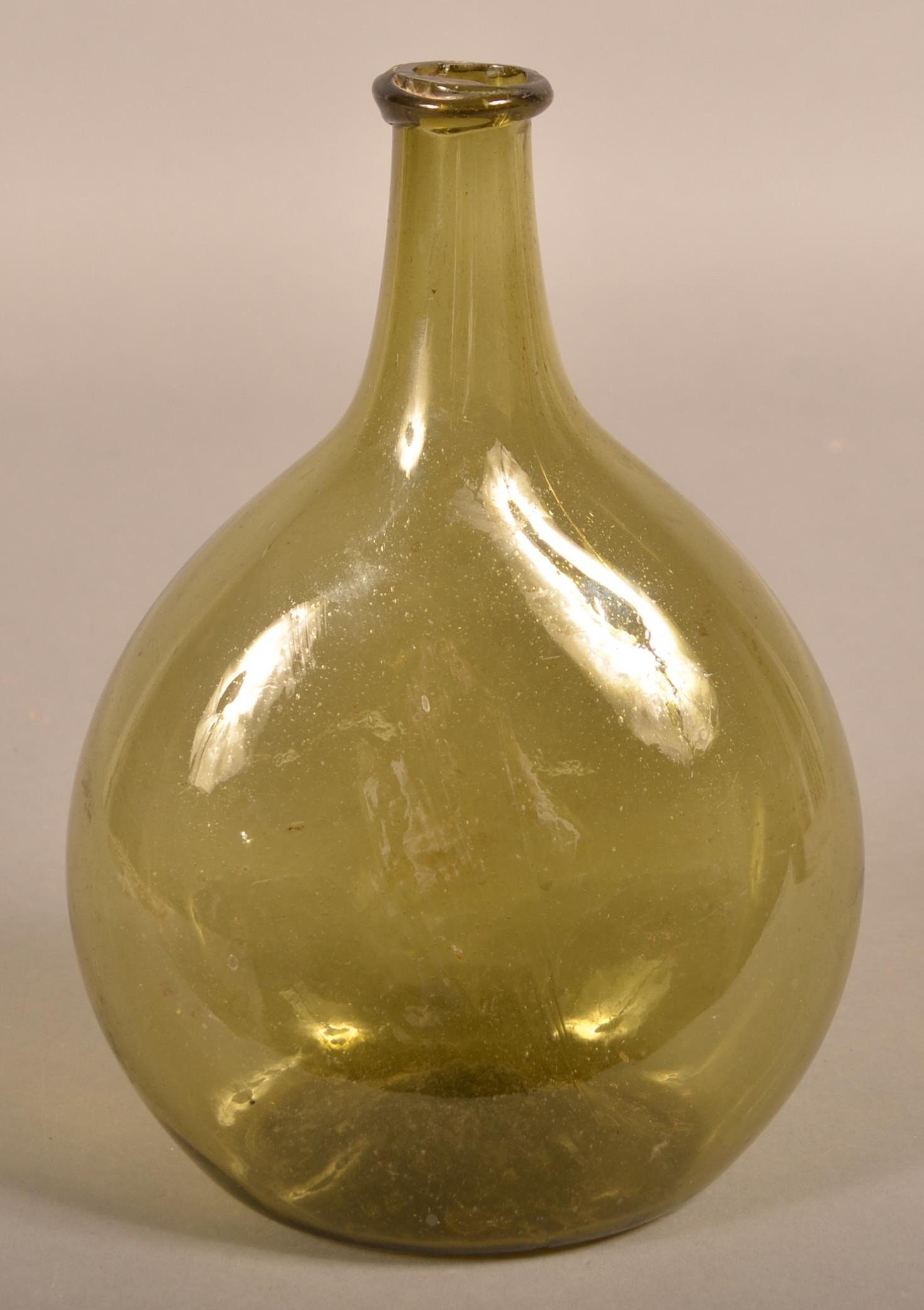 Free-Blown Light Olive Green Glass Chestnut Bottle.: Free-Blown Light Olive Green Glass Chestnut Bottle. Ovoid body, tapered neck with applied mouth and concave base with pontil. 10-1/4"h. Condition: Good with some flaking inside of mouth.