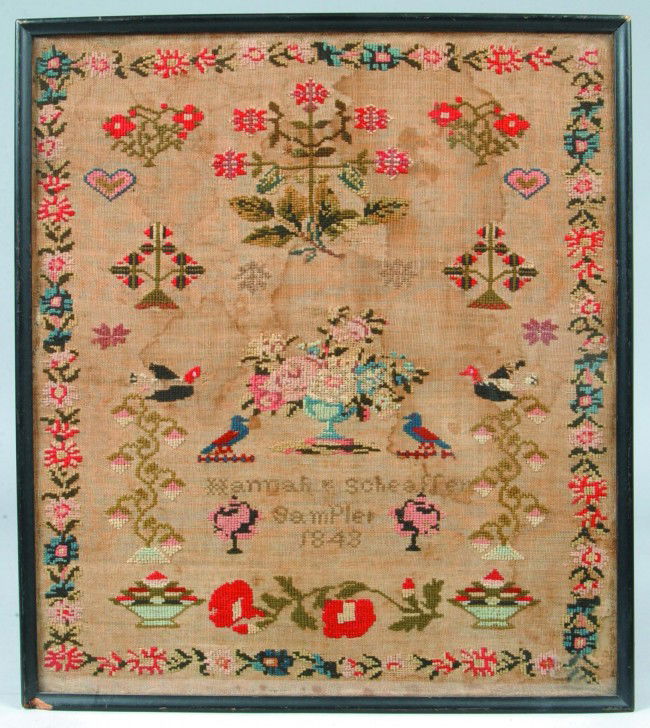 Hannah Scheafer 1843 Needlework Sampler having ce: Hannah Scheafer 1843 Needlework Sampler having central basket of flower flanked by birds, trees, flowers, floral and foliage border, 20 1/2"h. x 18"w. Condition: Stains and losses.