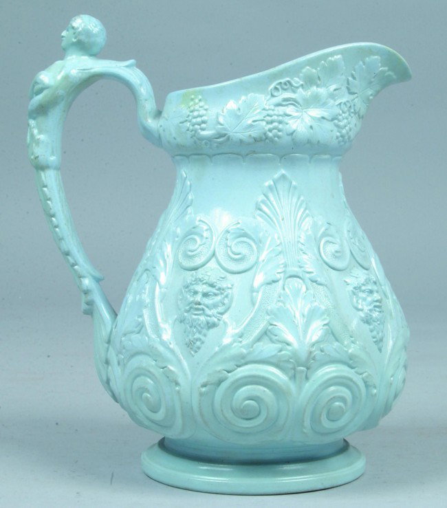 Blue Parian China Water Pitcher decorated with e: Blue Parian China Water Pitcher decorated with emossed faces, foliate and scroll, grape and vine, figural handle, 11"h, Condition: Spout chip repair.