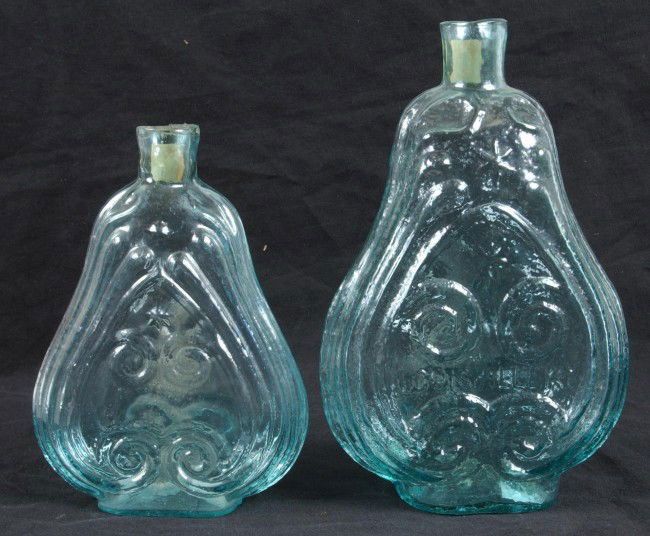 Two Blown Aquamarine Glass Scroll Design Flasks; L: Two Blown Aquamarine Glass Scroll Design Flasks; Larger marked "Louisville Glass Works" 8 1/2" High, second is unkmarked,7" high Condition: Good.
