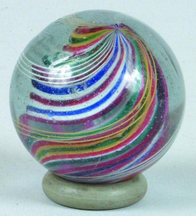 Solid Core Swirl Marble consisting of red, blue, gr: Solid Core Swirl Marble consisting of red, blue, green, yellow and white with outer lines of yellow and white. 2" diam. Condition: Good with two minor chips and wear.