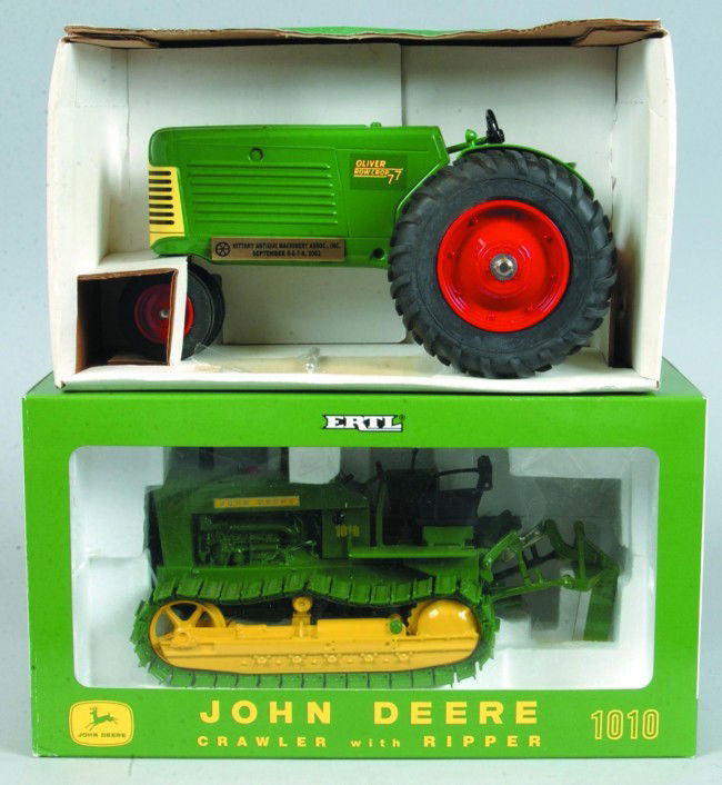 Two 1:16 Scale Die Cast Metal Tractors; Ertl John: Two 1:16 Scale Die Cast Metal Tractors; Ertl John Deere 1010 Crawler with Ripper and Spec Cast SCT 104 Oliver 77 Row Crop with narrow front. Condition: New in box.