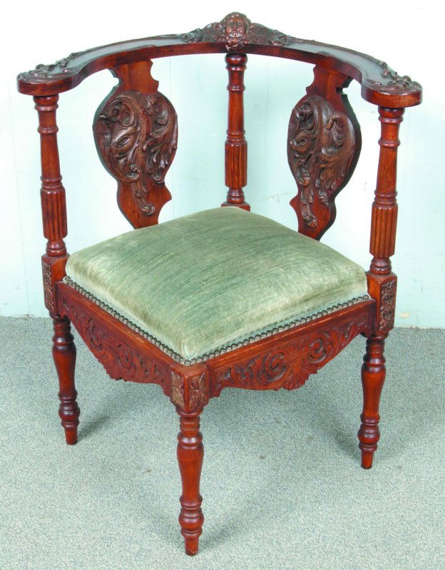 Ornate Victorian Mixed wood Carved and Molded Corn: Ornate Victorian Mixed wood Carved and Molded Corner Chair with central Cherub carving on crest rail and green velour upholstered seat. Seat Height 18", 31" high overall. Condition: good with some rep