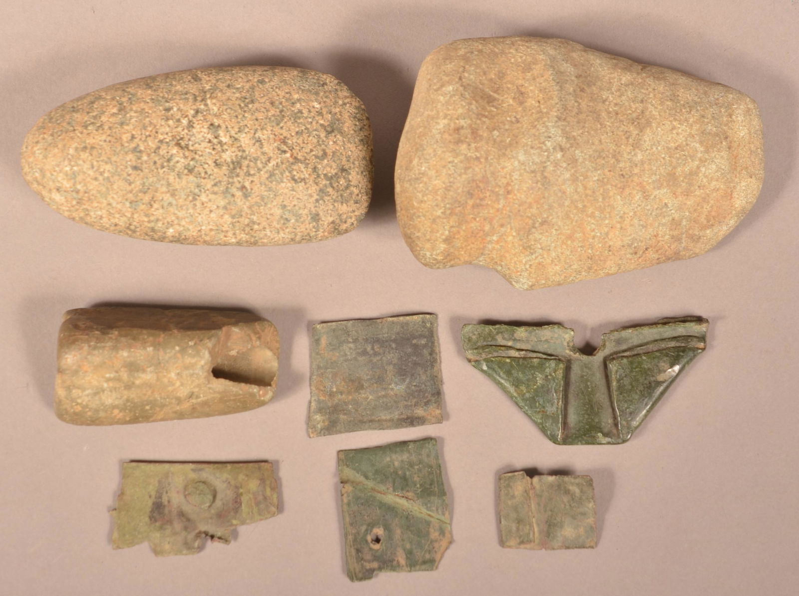 Lot of Prehistoric and Historic Artifacts.: Lot of Prehistoric and Historic Artifacts. Including a 3/4 grooved axe head, 4-1/2"l., a granite Celt, 4-1/4"l., a tube bannerstone, 2-1/2"l. and Susquehannock brass items. Condition: Good.
