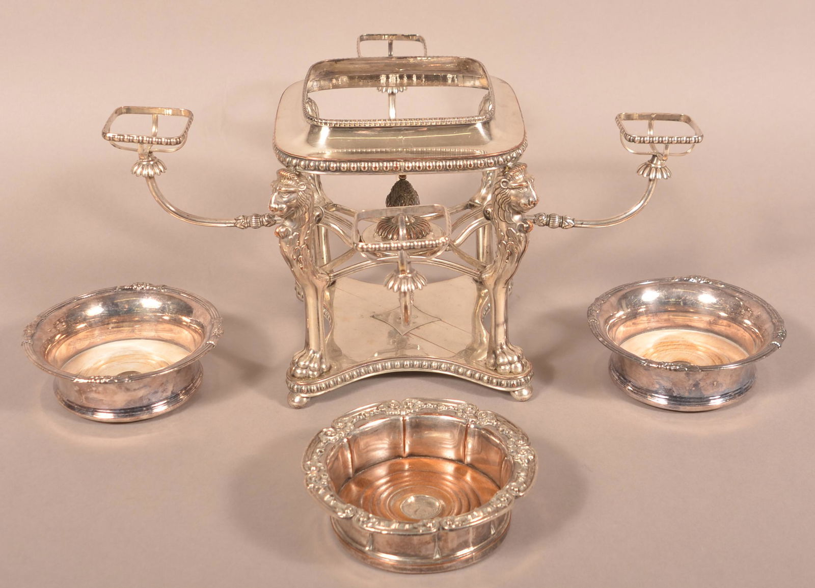 Lot of 19th Century Silver-Plate Items.: Lot of 19th Century Silver-Plate Items. Including three wine bottle coasters and a chaffing dish stand with lion head and paw foot supports, 10"h. Condition: Good with use wear.